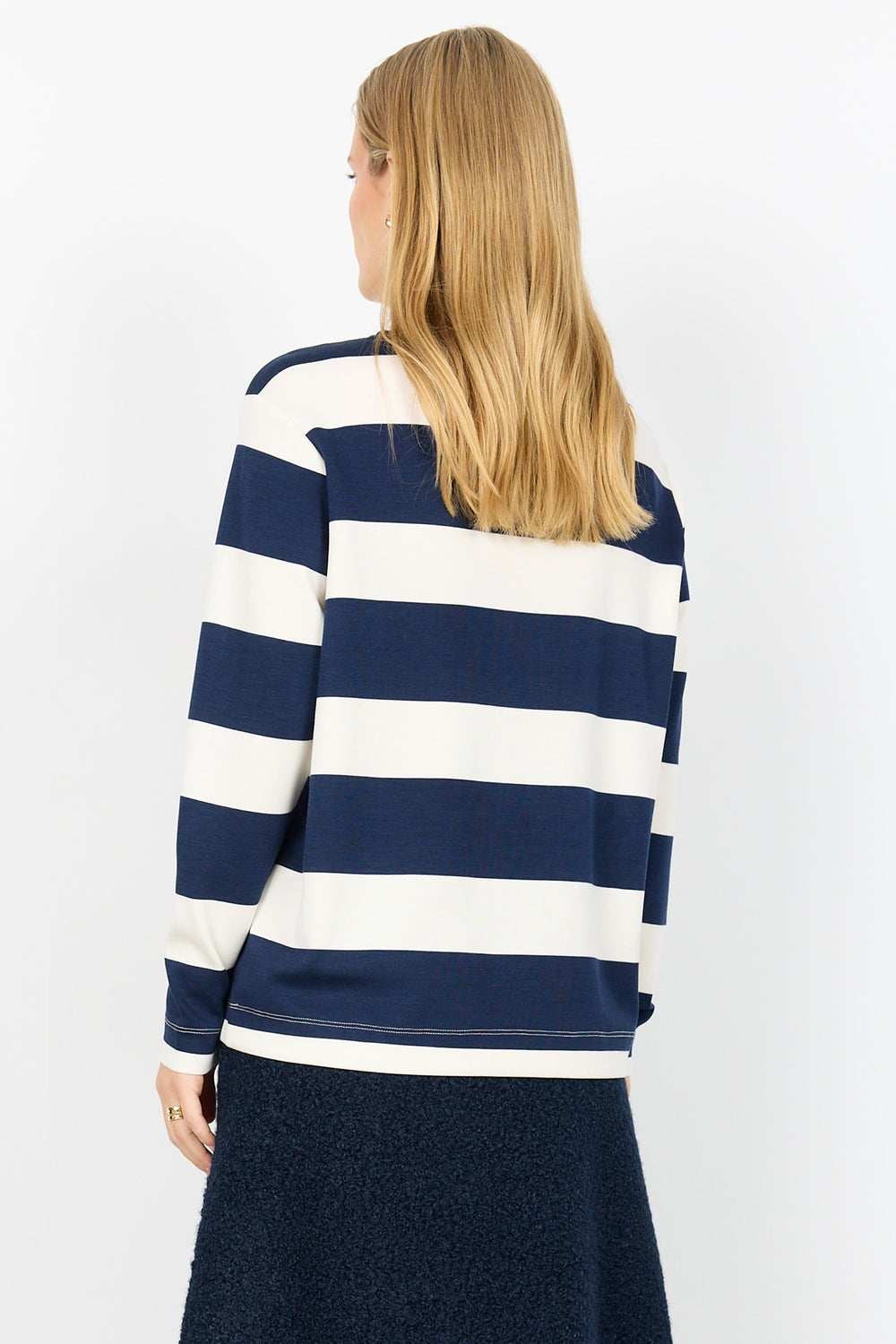 Woman wearing a navy and white striped sweater on a white background