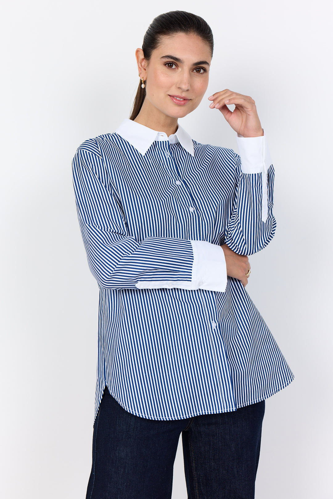 Woman wearing a blue and white striped shirt with a white collar on a white background
