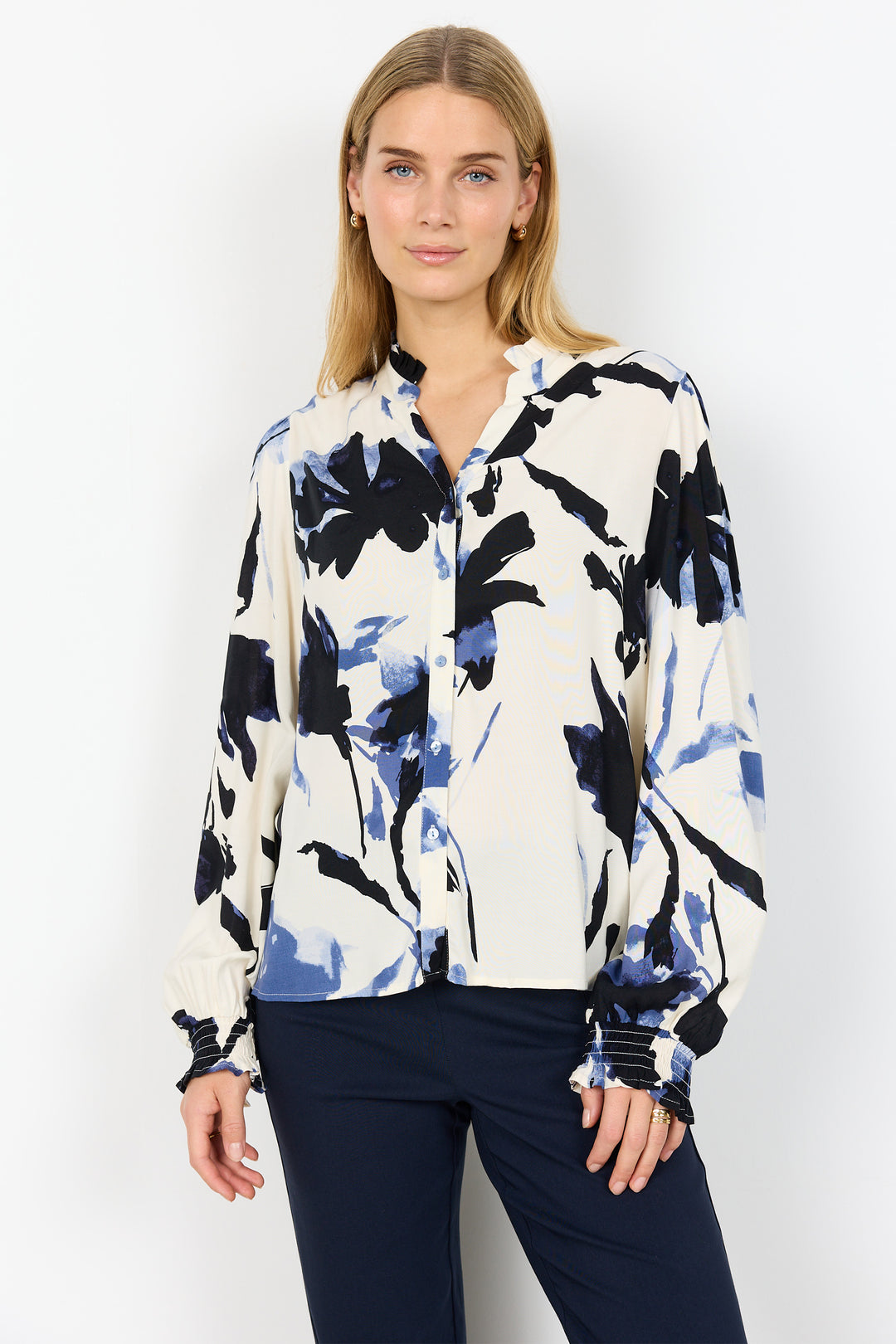 Woman wearing a long-sleeve shirt with a black and blue abstract pattern on a white background