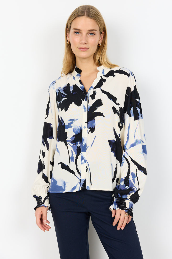 Woman wearing a long-sleeve shirt with a black and blue abstract pattern on a white background