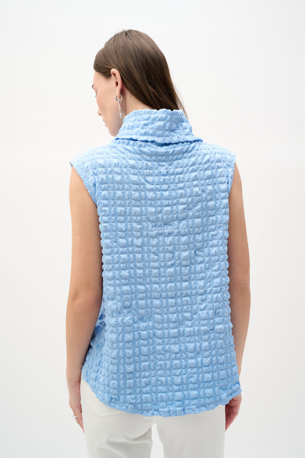 Woman wearing a light blue textured tank top  on a white background