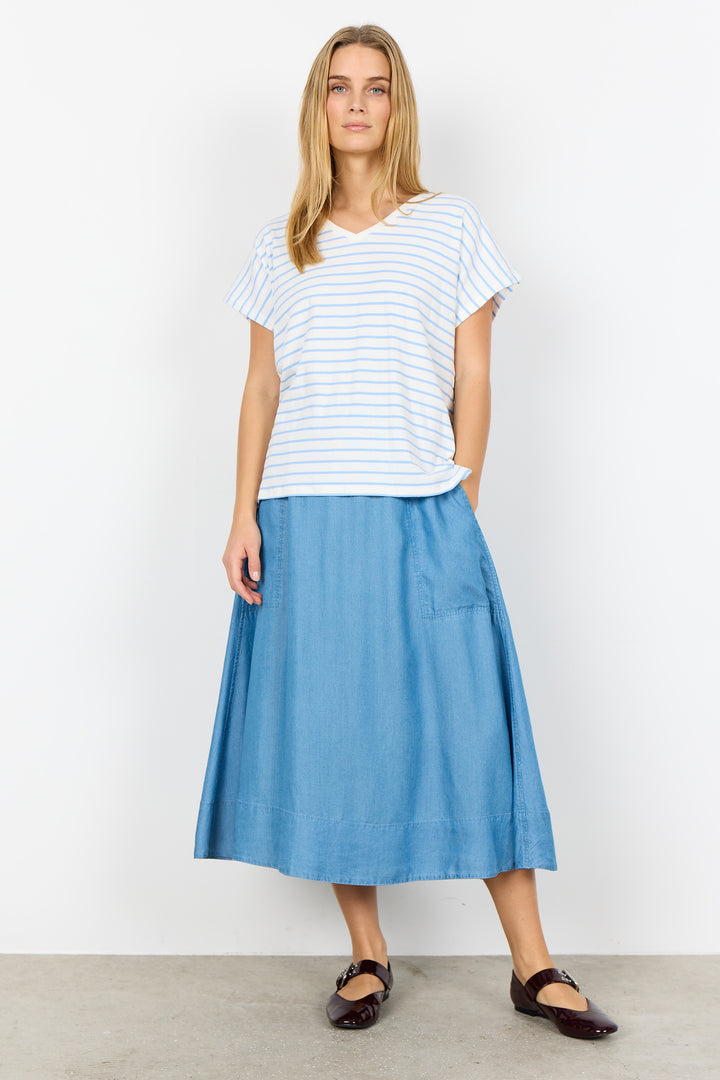 Woman wearing a striped shirt and blue skirt on a white background