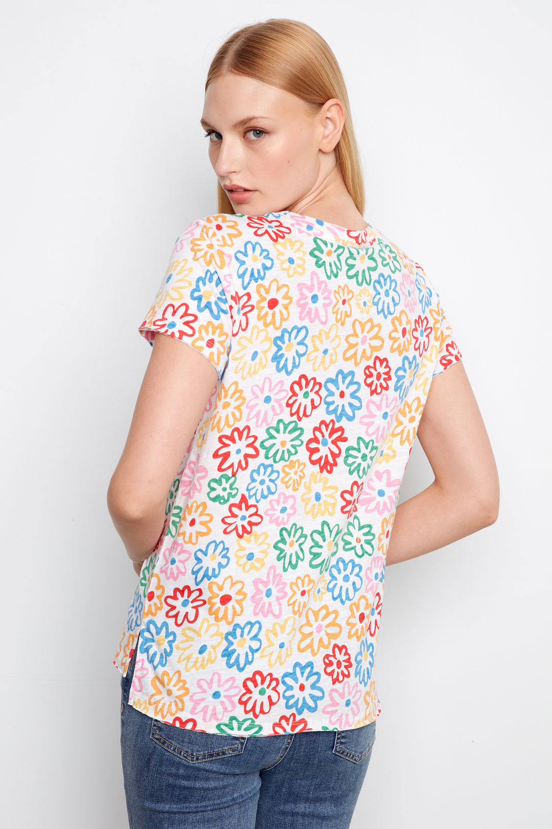Woman wearing a colorful floral-patterned shirt against a white background