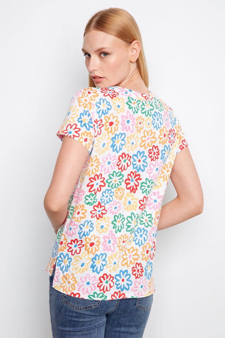 Woman wearing a colorful floral-patterned shirt against a white background