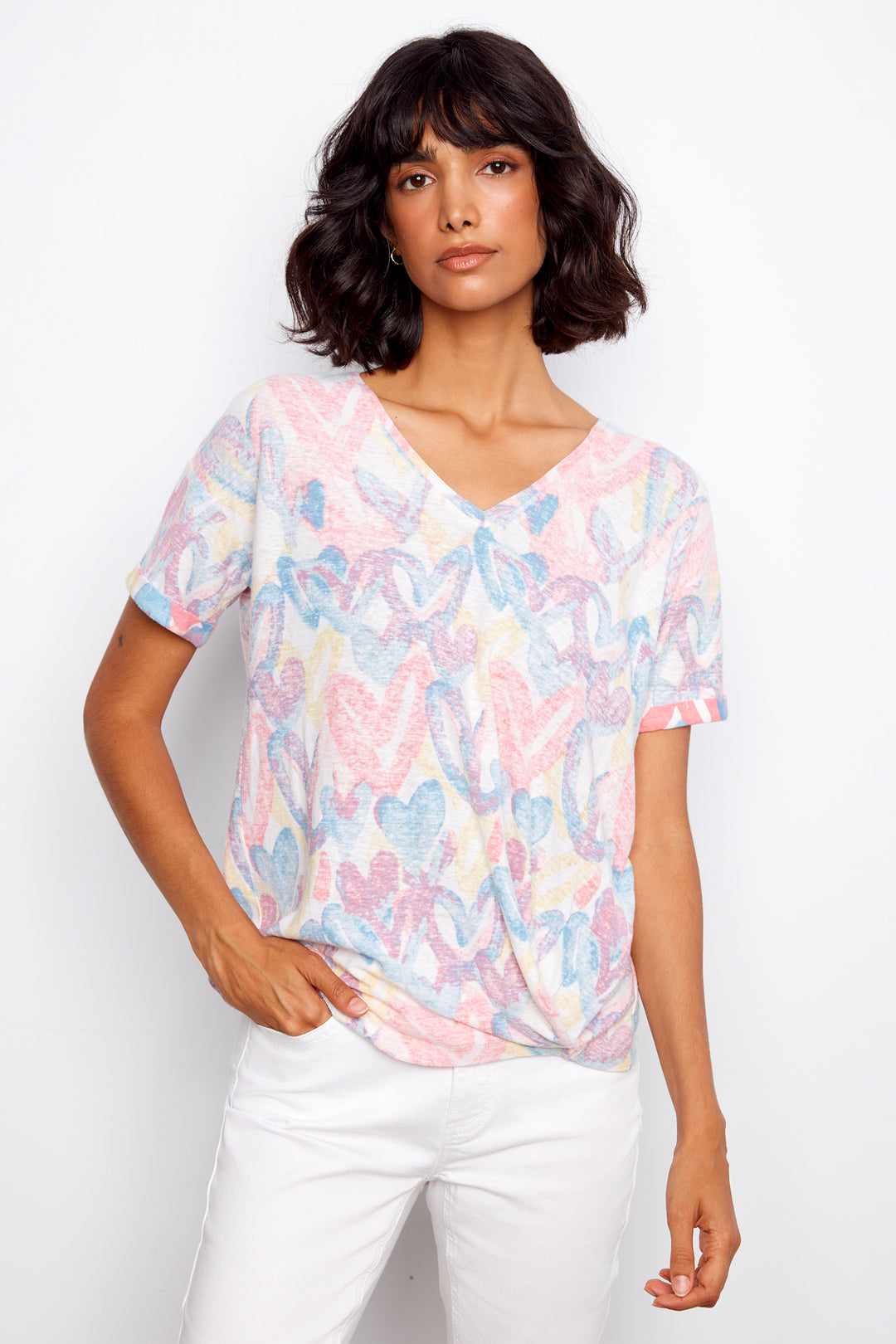 Woman wearing a pastel butterfly patterned top against a white background