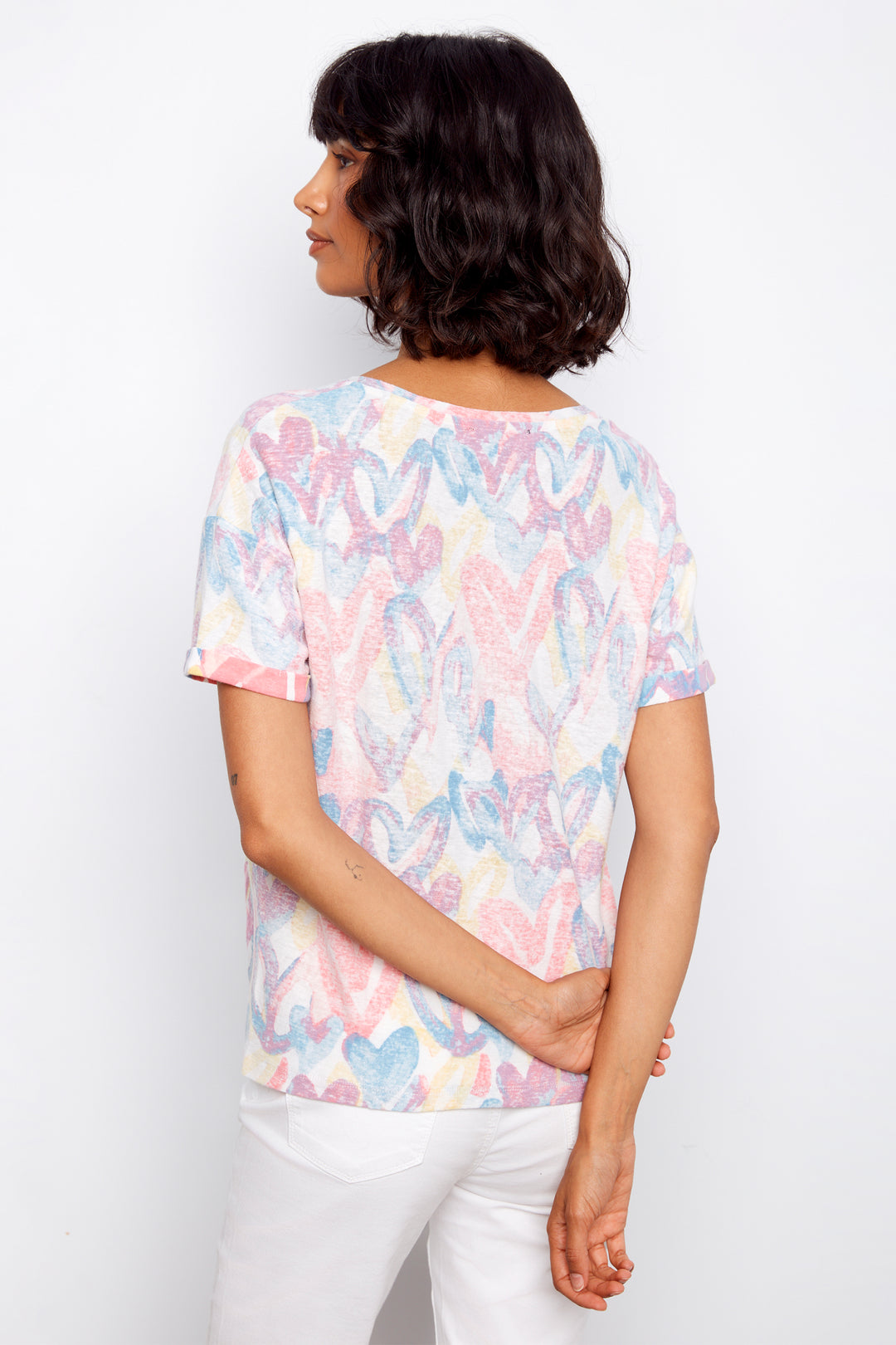 Woman wearing a pastel floral patterned t-shirt against a white background