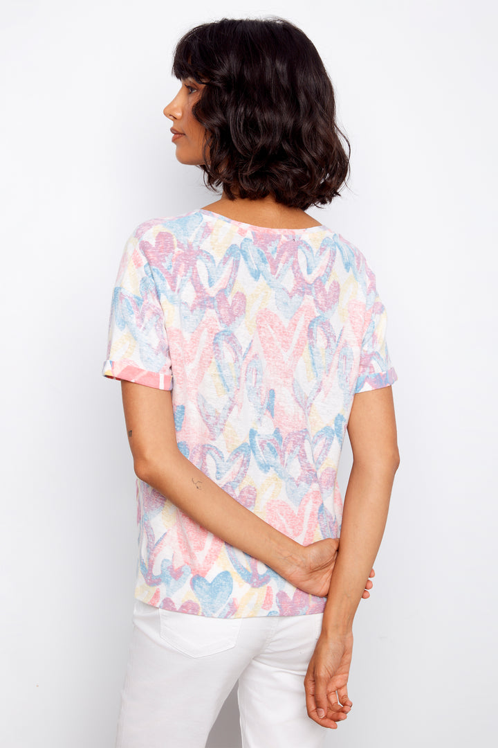Woman wearing a pastel floral patterned t-shirt against a white background