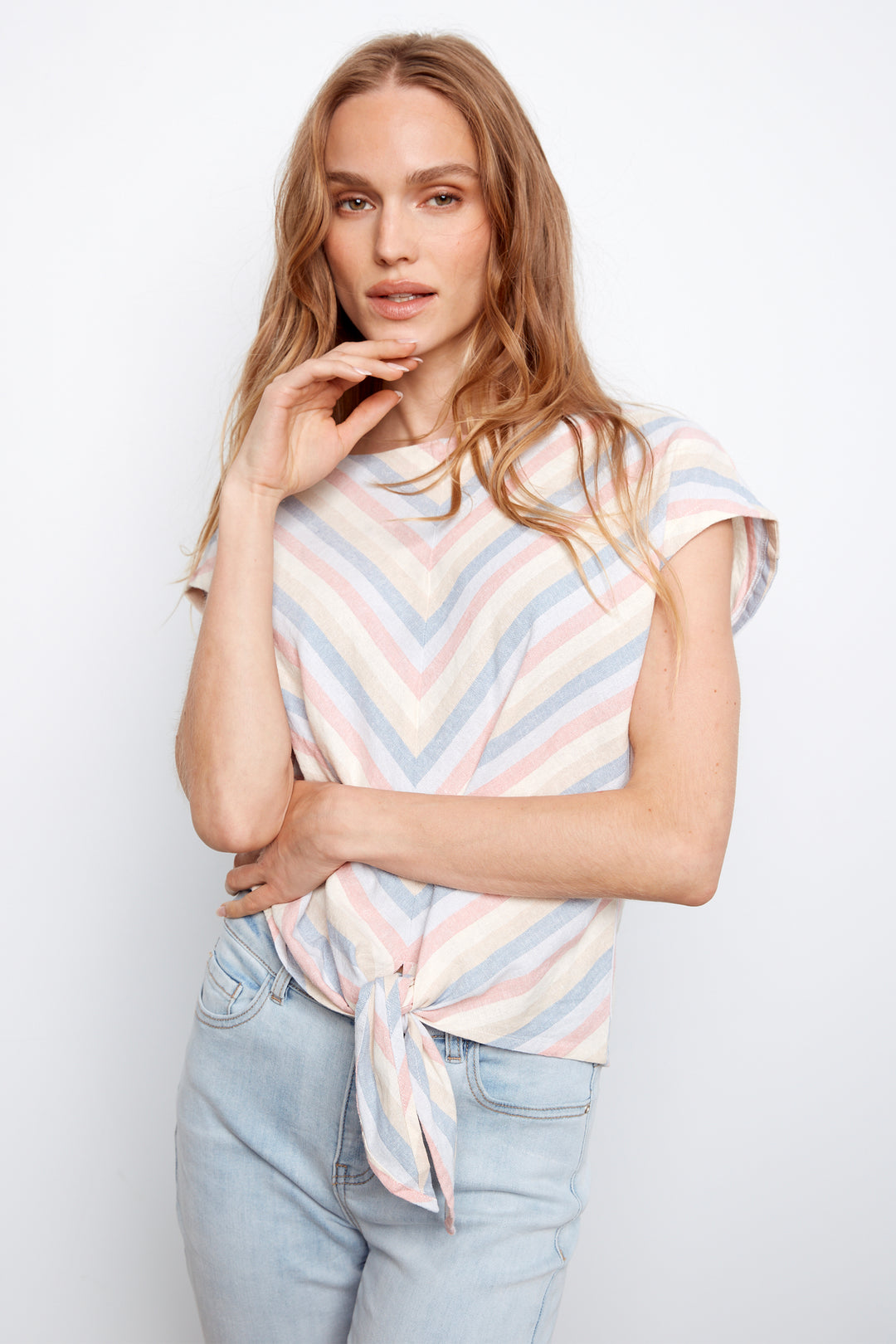 Woman wearing a striped shirt and jeans against a white background