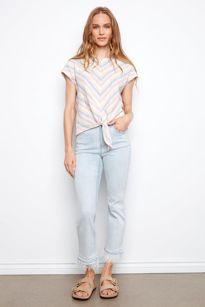 Woman wearing a striped shirt and light blue jeans against a white background