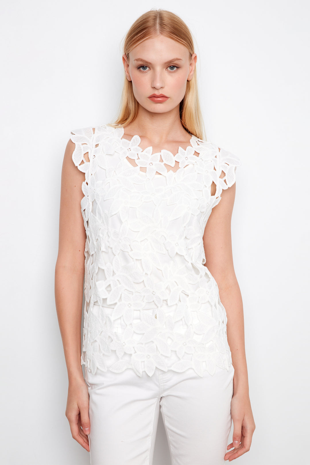 Woman wearing a white lace top against a white background