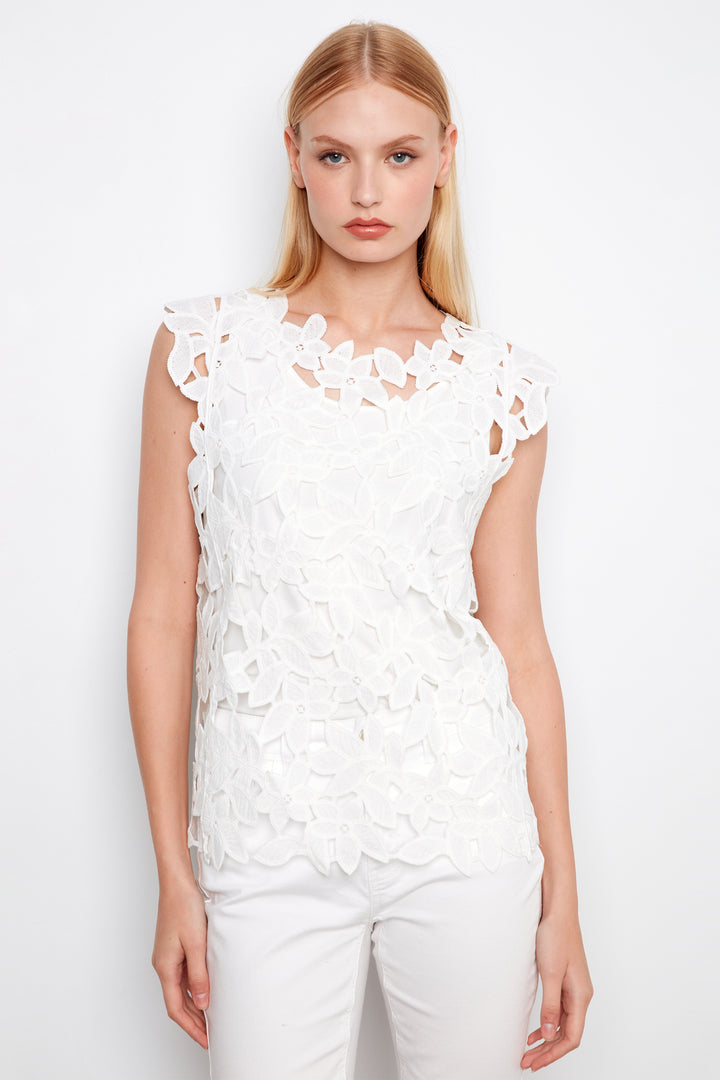Woman wearing a white lace top against a white background