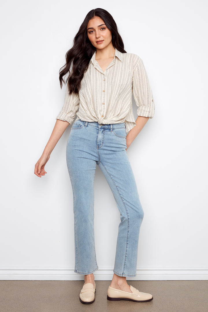 Woman wearing a striped shirt and light blue jeans against a white background