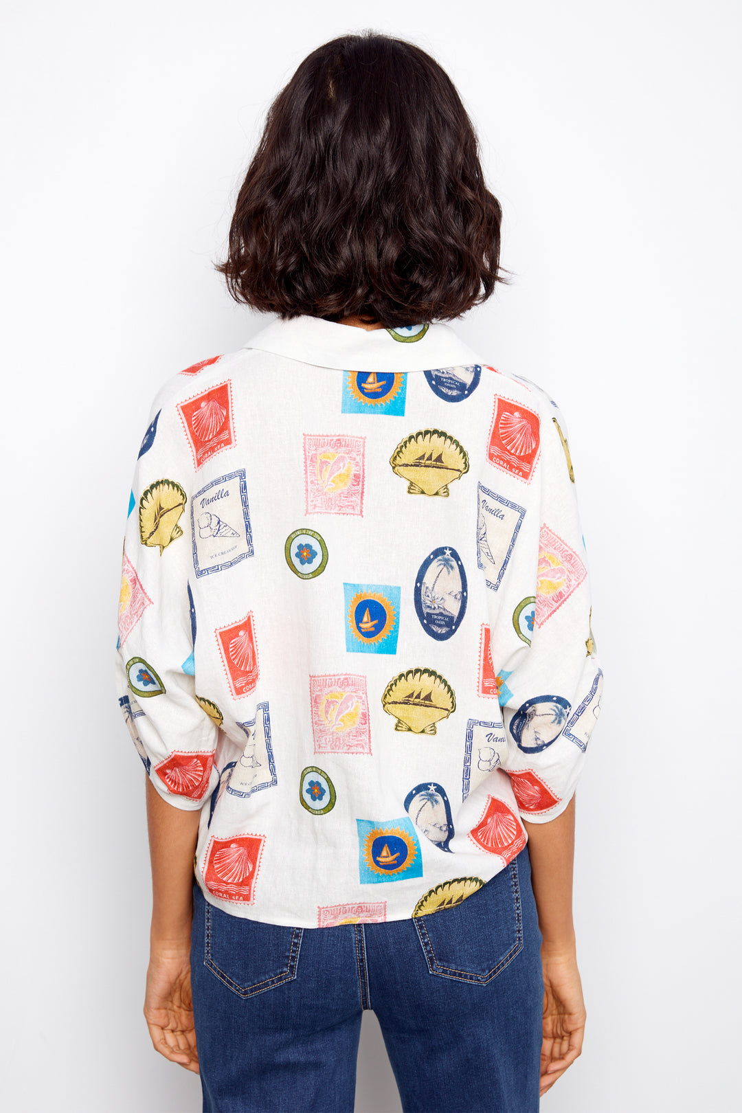 Person wearing a colorful patterned shirt with a plain background