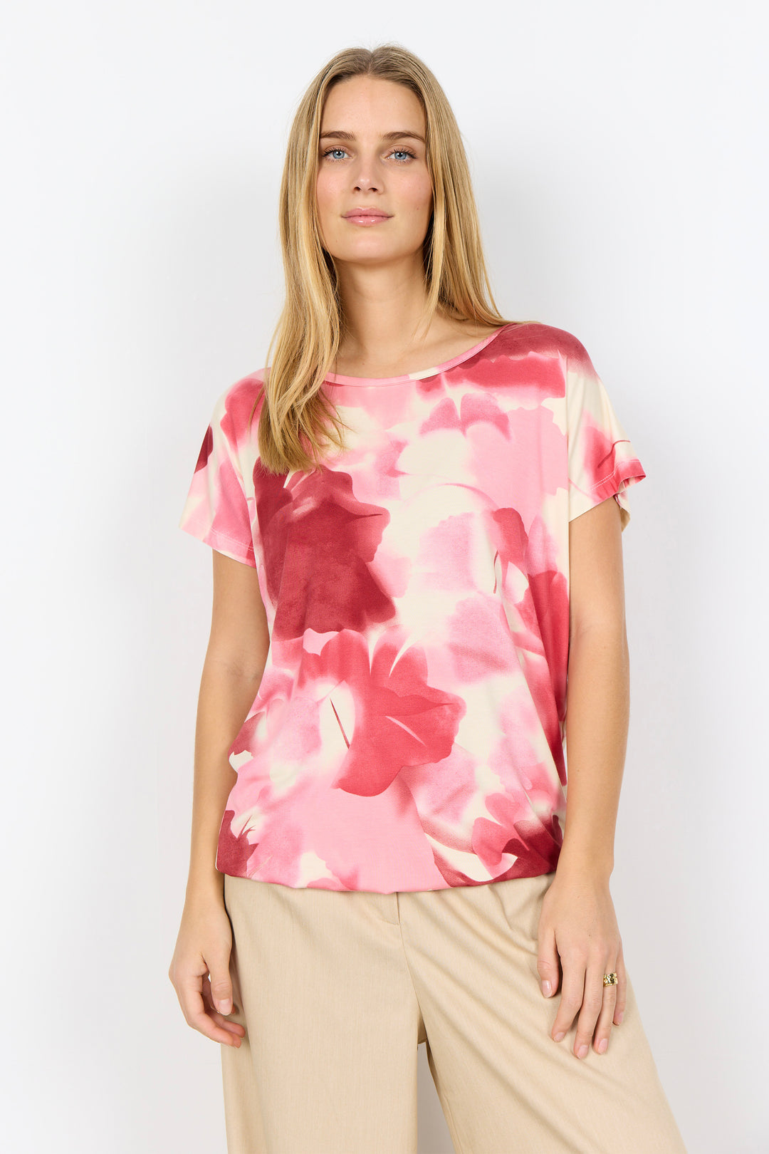 Woman wearing a pink floral t-shirt against a white background