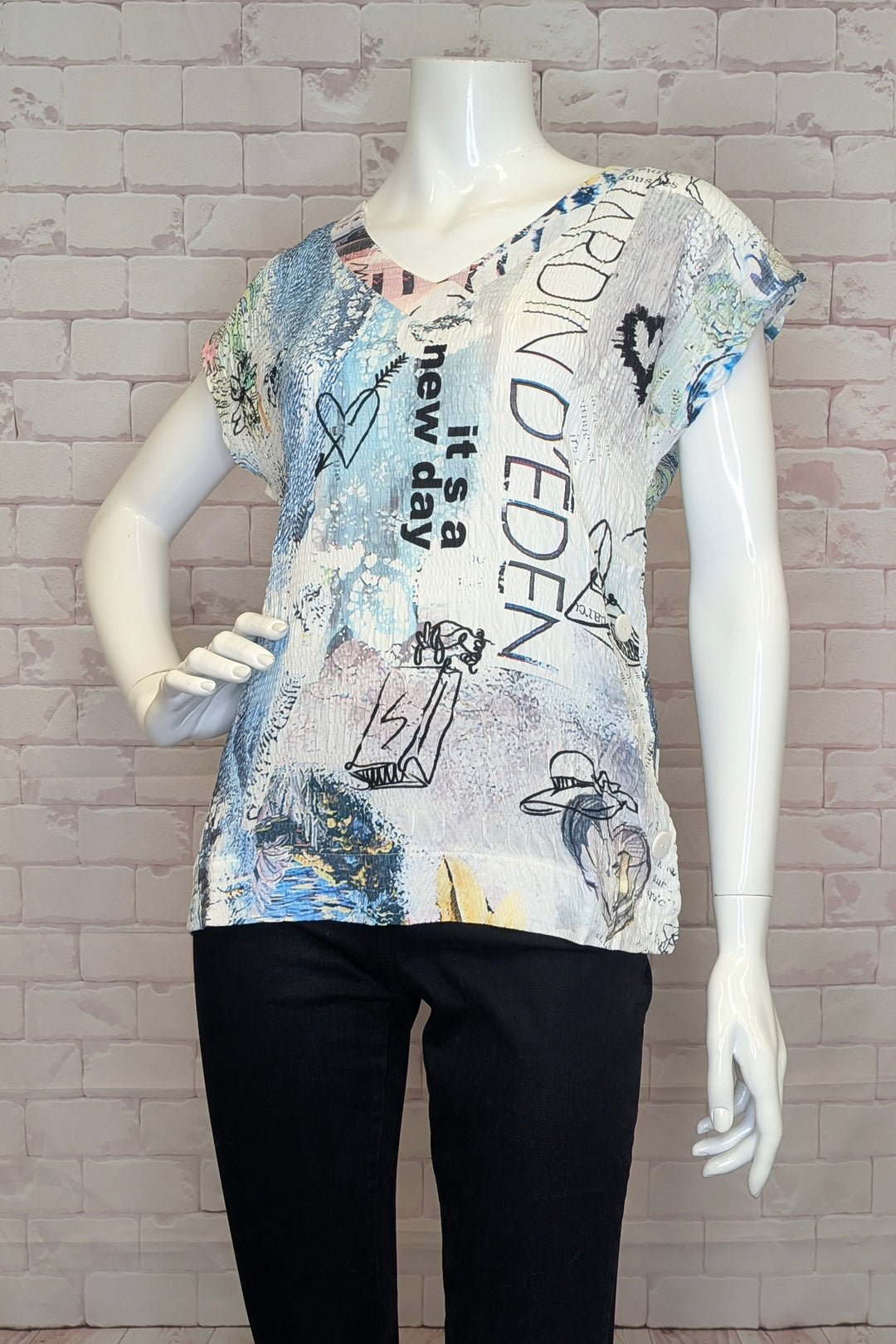 Mannequin wearing a graphic t-shirt with text and designs against a brick wall background