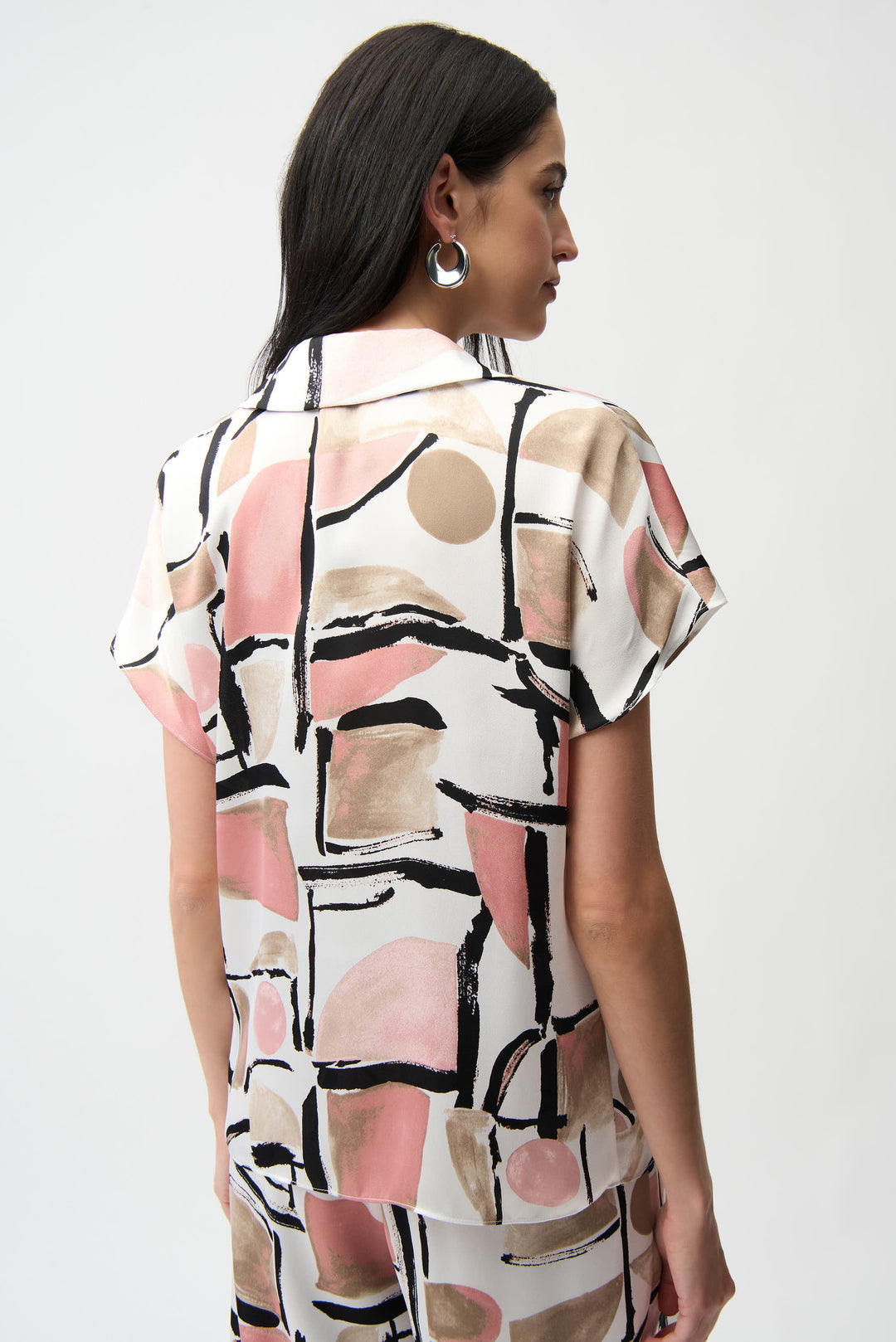 Woman wearing a patterned dress with abstract design on a white background