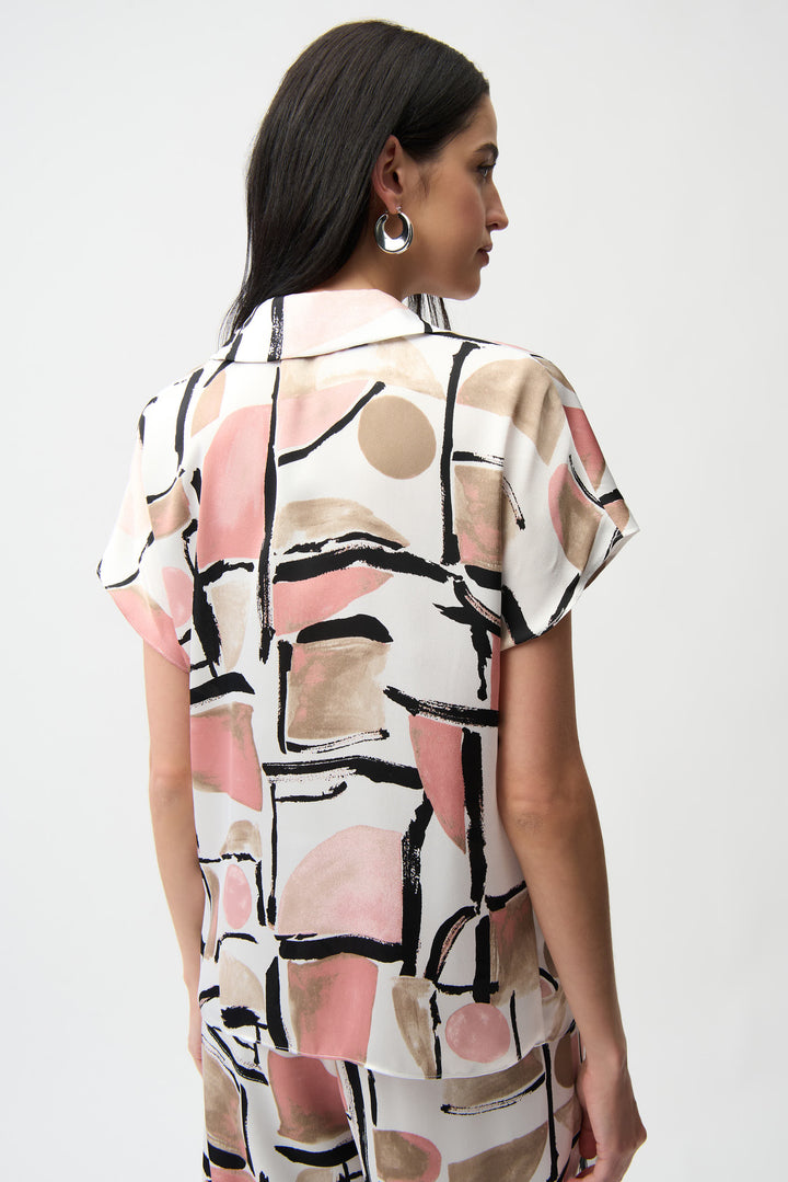 Woman wearing a patterned dress with abstract design on a white background