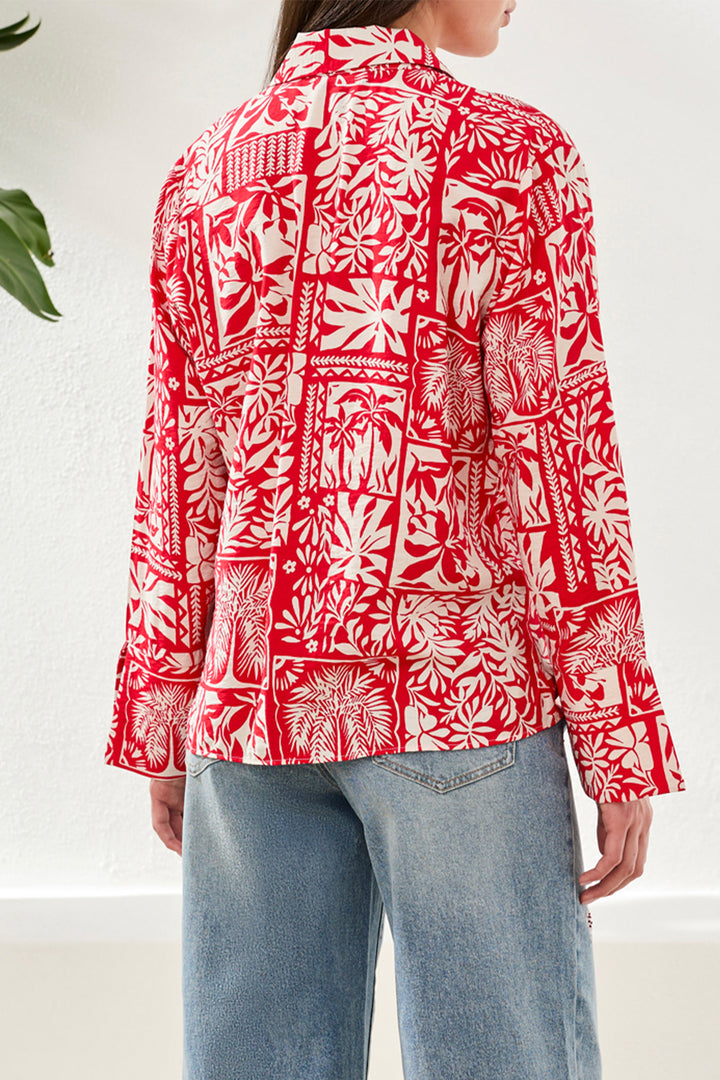 Person wearing a red and white patterned shirt with blue jeans on a white background