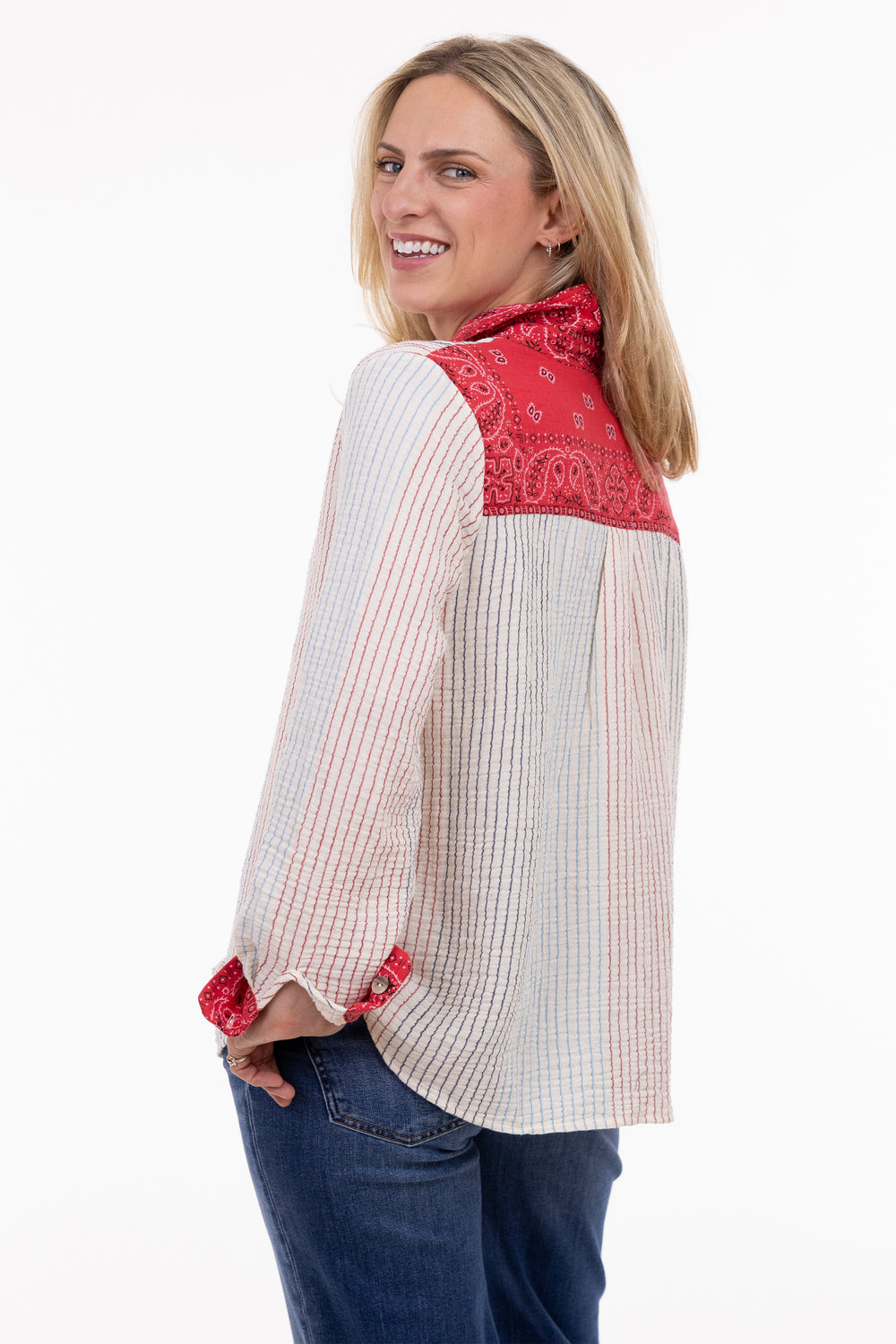 Woman wearing a red and white patterned shirt with rolled-up sleeves on a white background