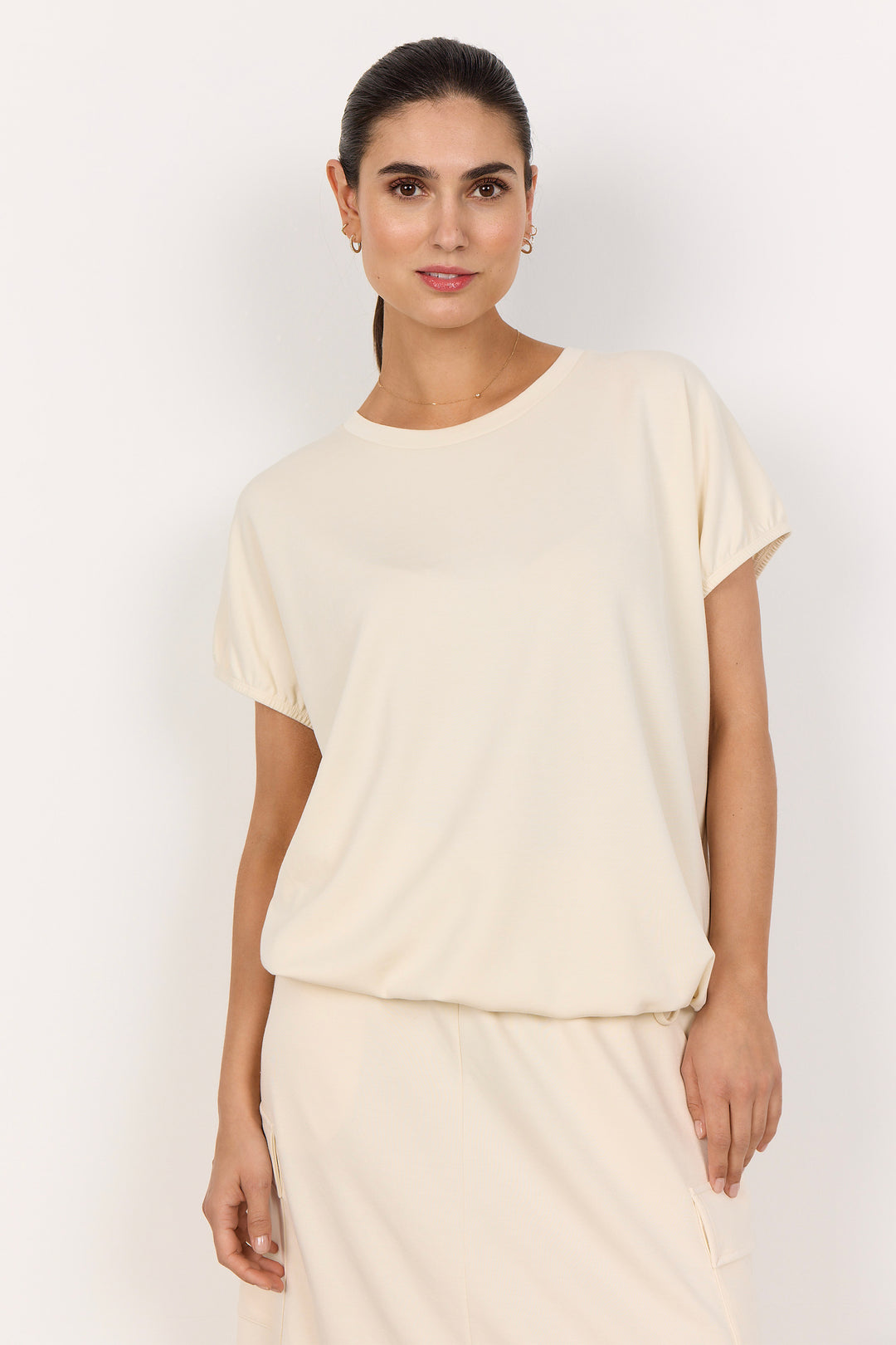 woman wearing a cream coloured t-shirt on white background