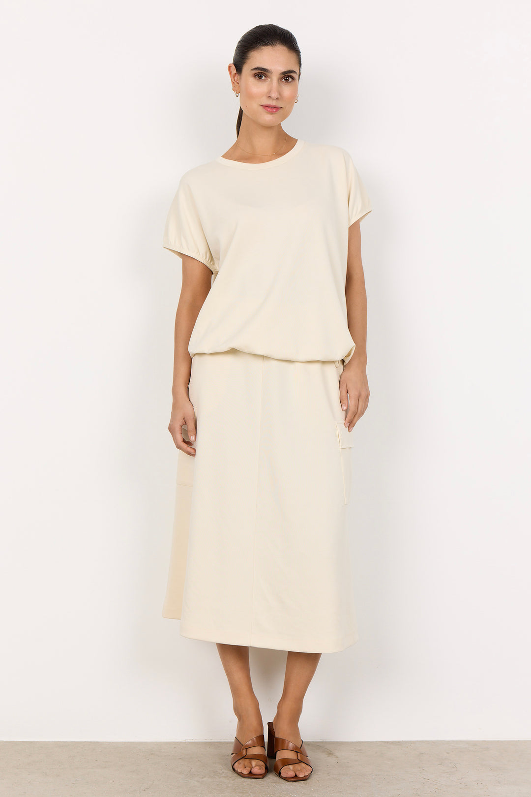 woman wearing a cream coloured t-shirt on white background