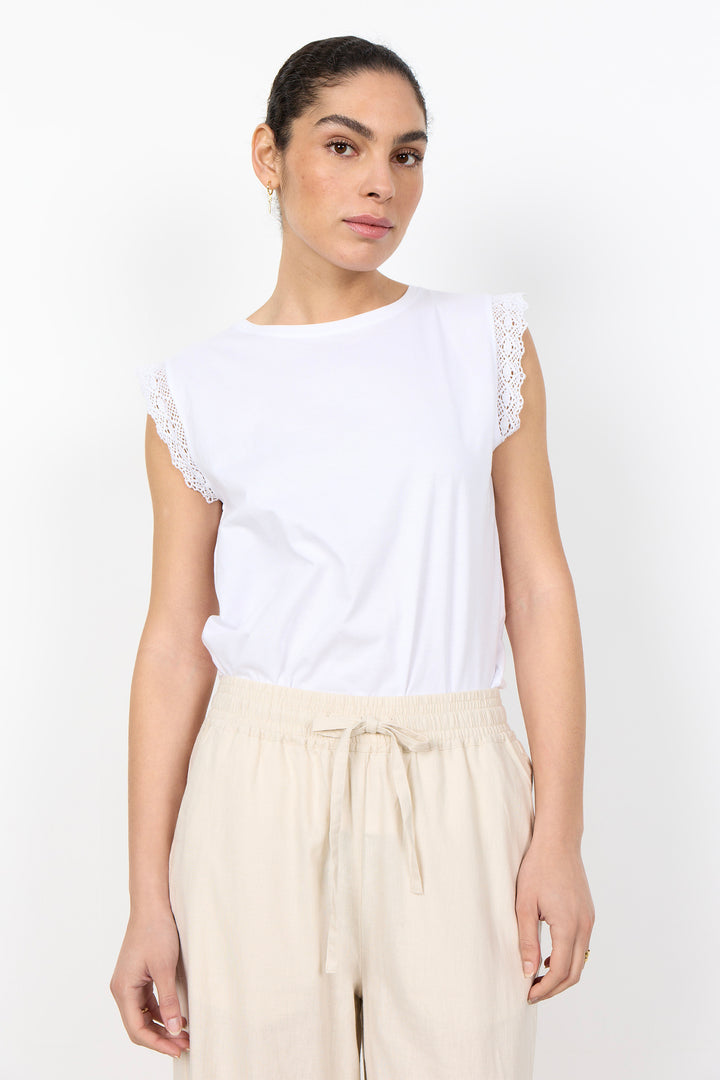 woman wearing white t-shirt with lace details on sleeves on a white background. 