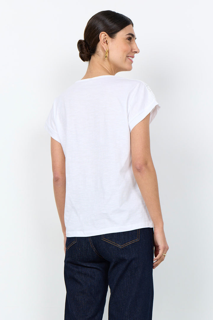 woman wearing a casual t-shirt with lace detail along neckline on a white background. 