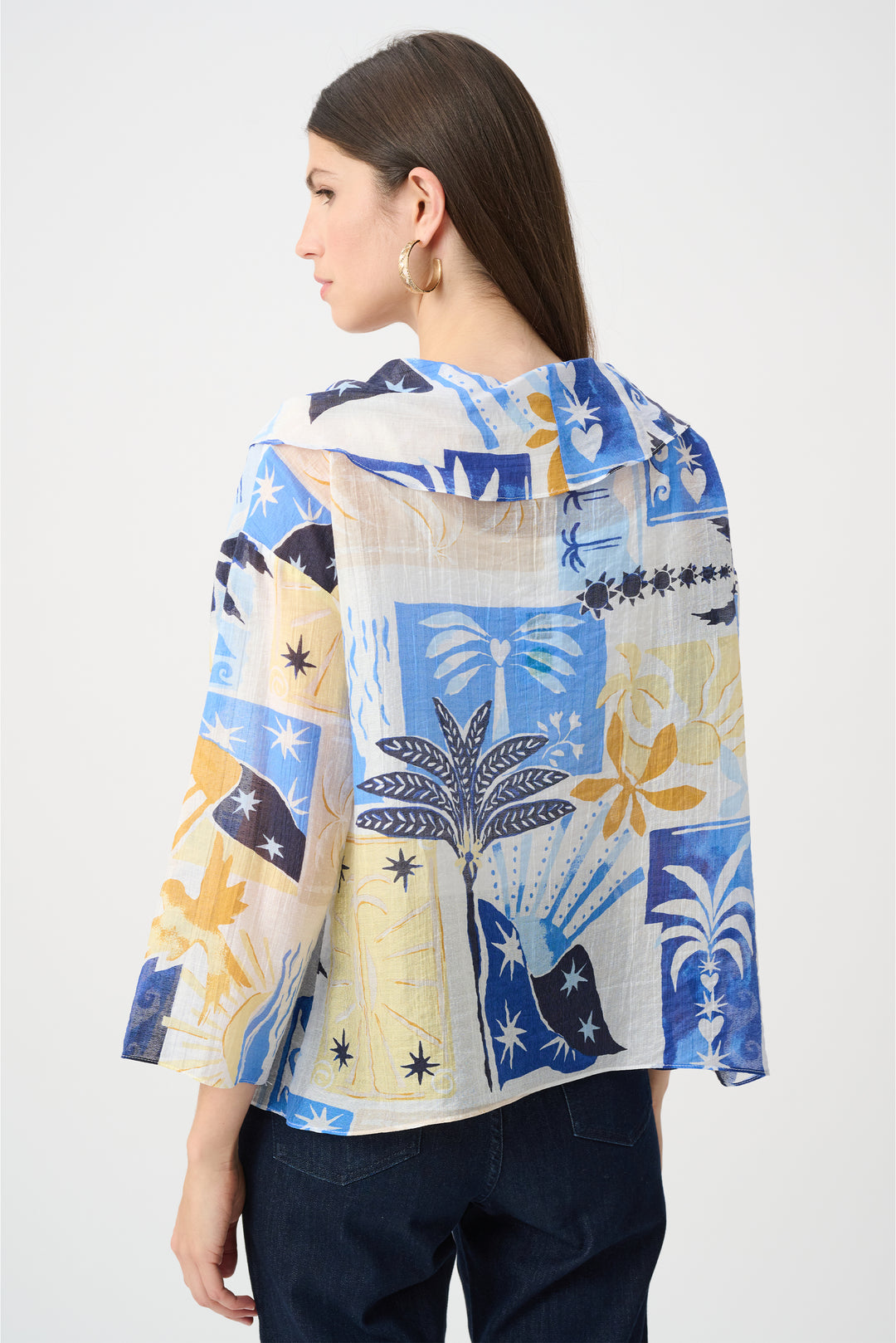 Woman wearing a colorful patterned blouse with a white background