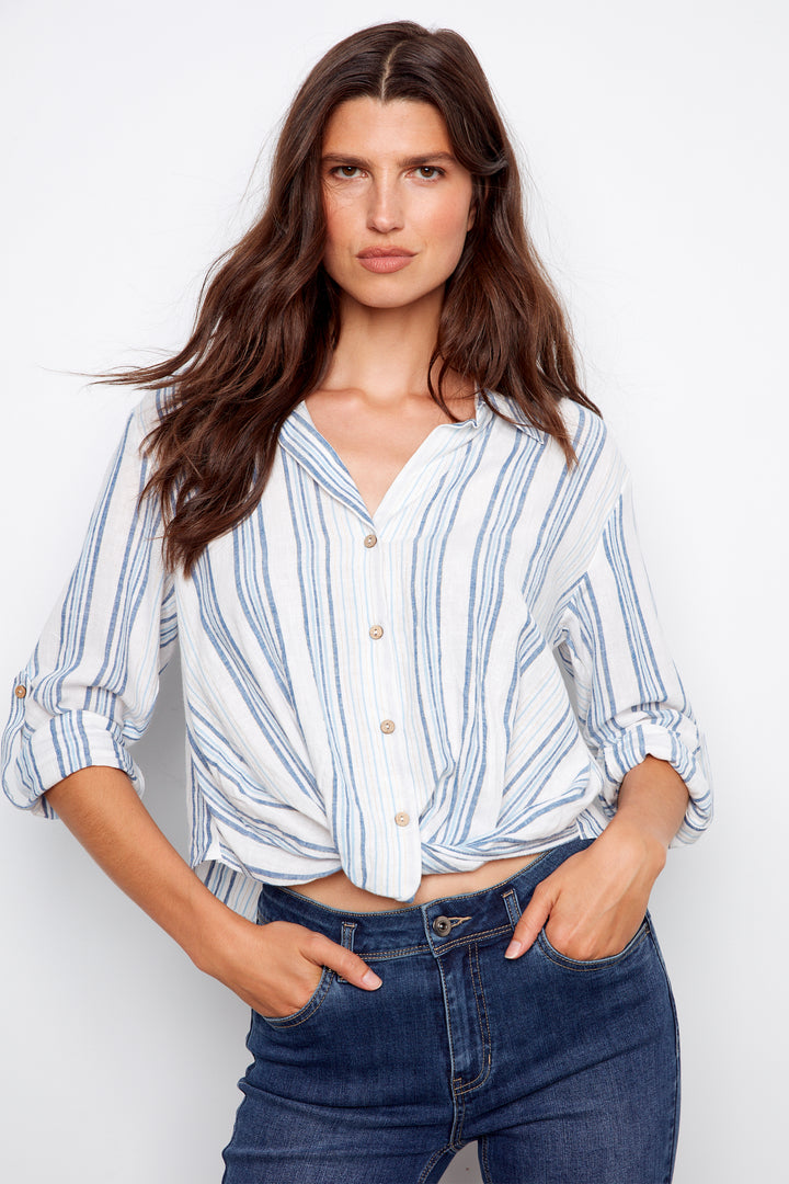 Woman wearing a striped shirt and jeans against a white background