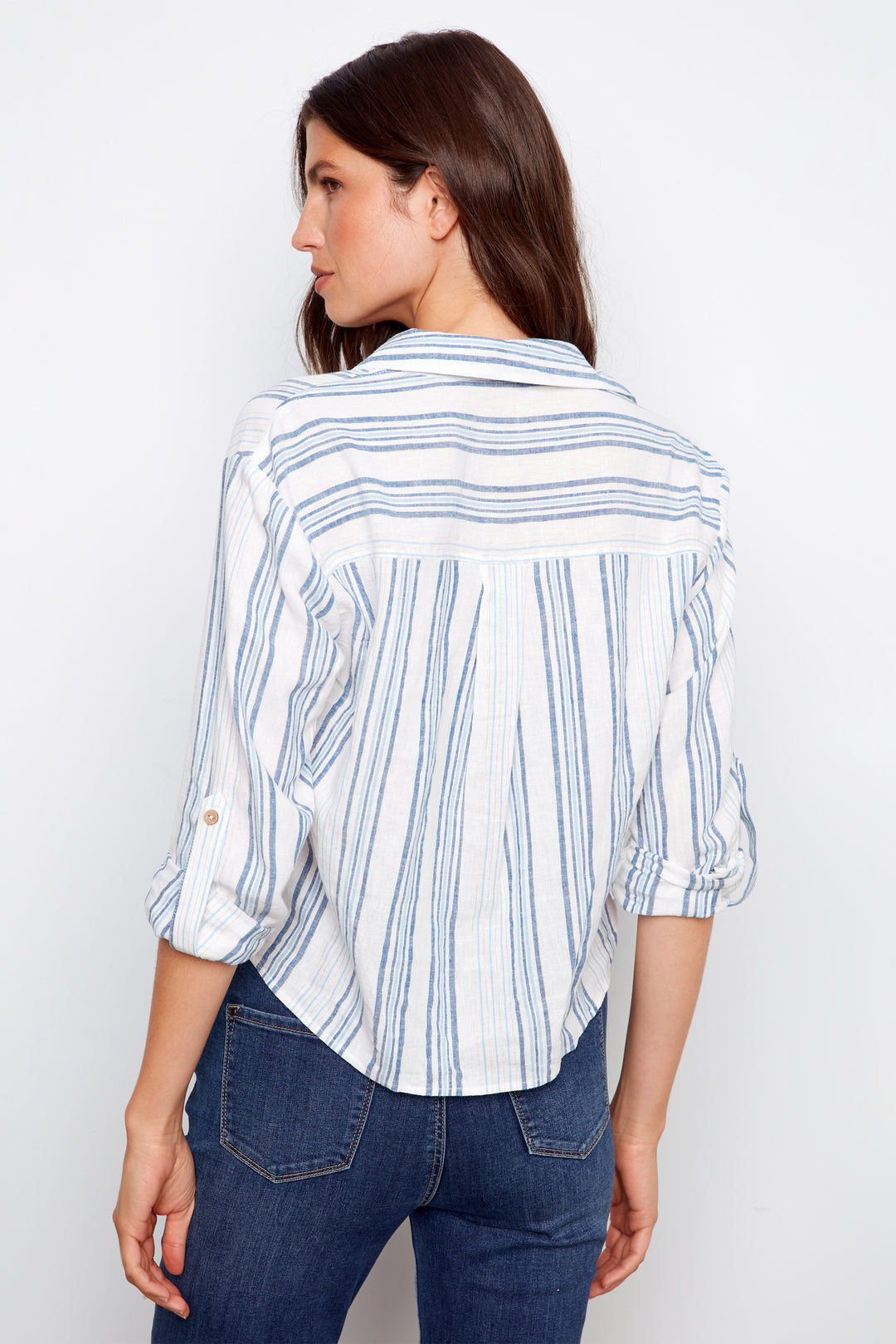 Woman wearing a striped shirt and jeans against a white background