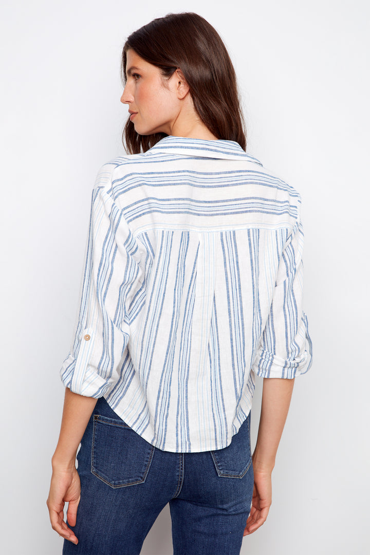 Woman wearing a striped shirt and jeans against a white background
