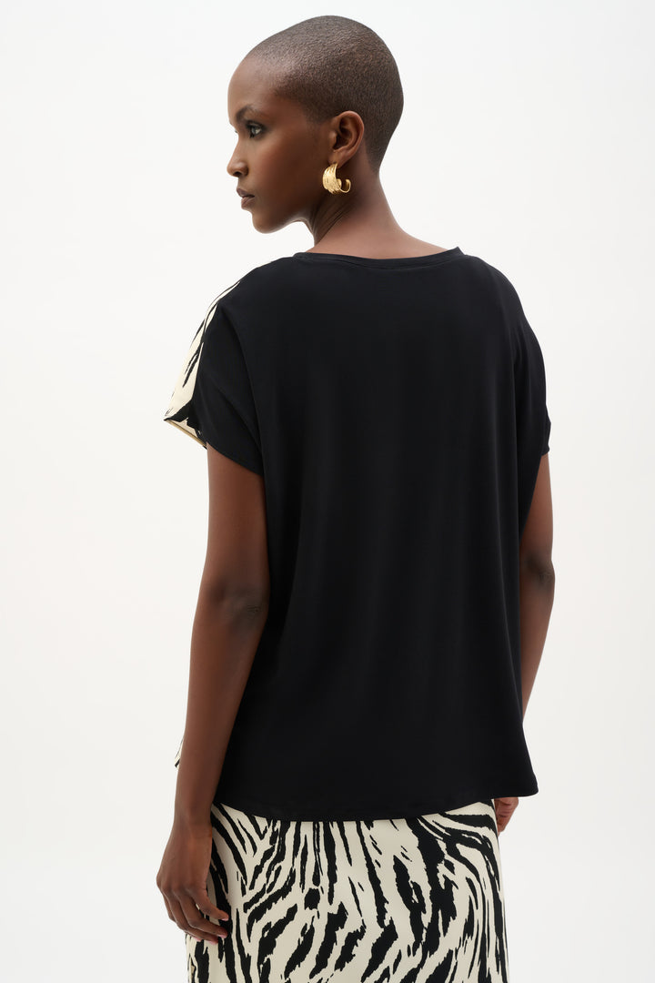 Woman wearing a black top with a zebra print skirt on a white background