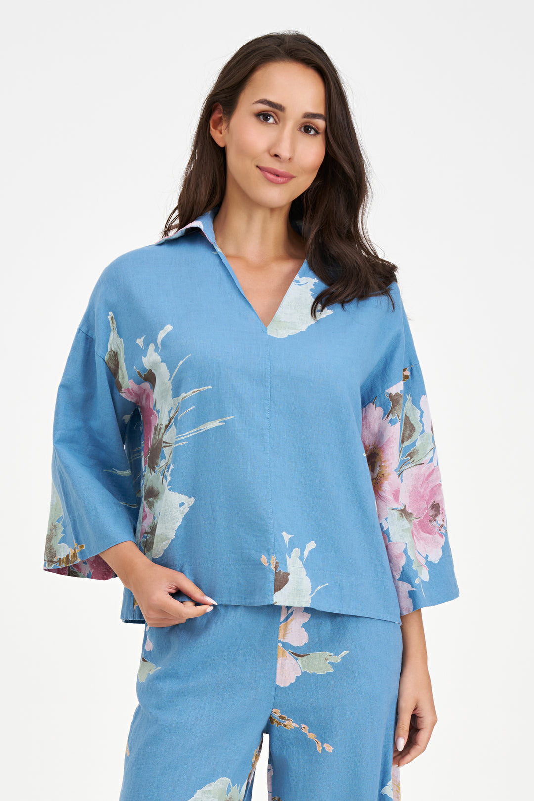 Woman wearing a blue floral pajama set on a white background