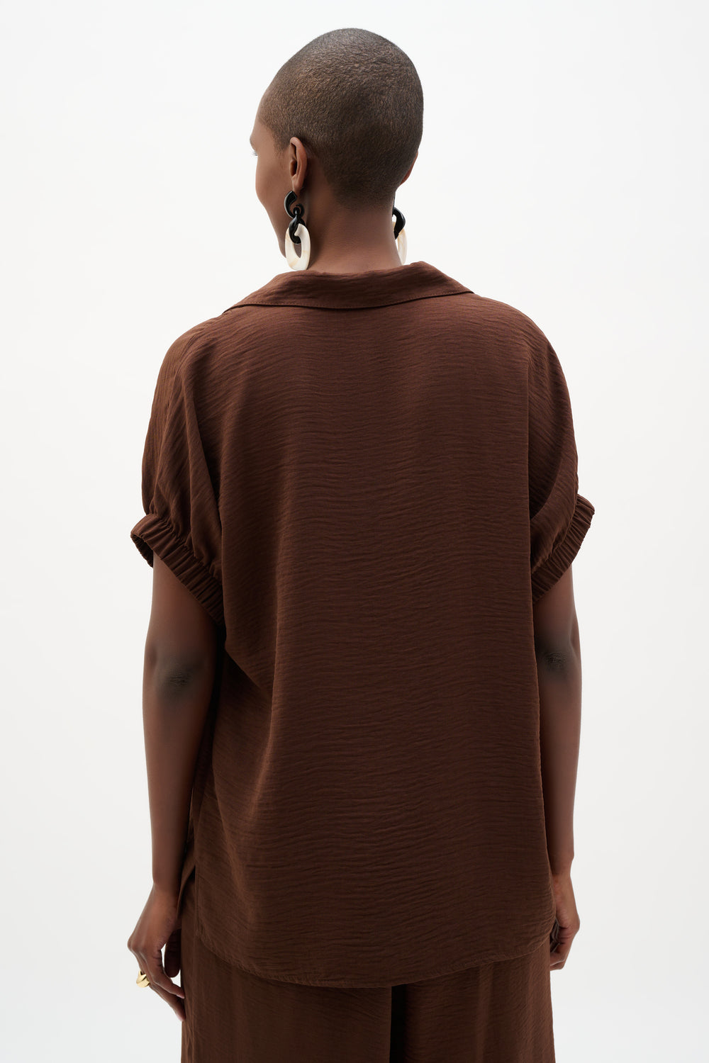 Person wearing a brown outfit on a white background