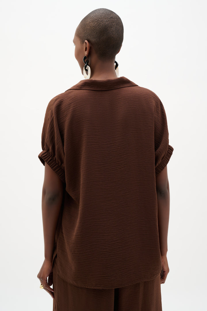 Person wearing a brown outfit on a white background