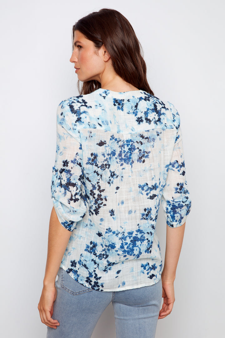 Woman wearing a floral blouse with a plain background