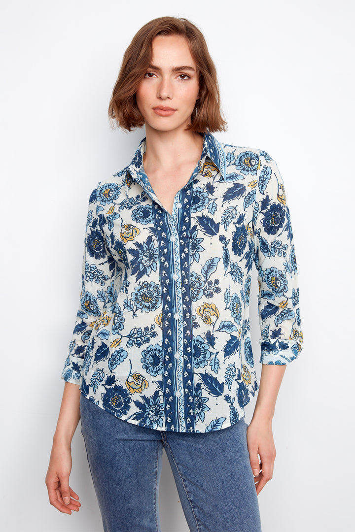 Woman wearing a blue floral shirt and jeans on a white background