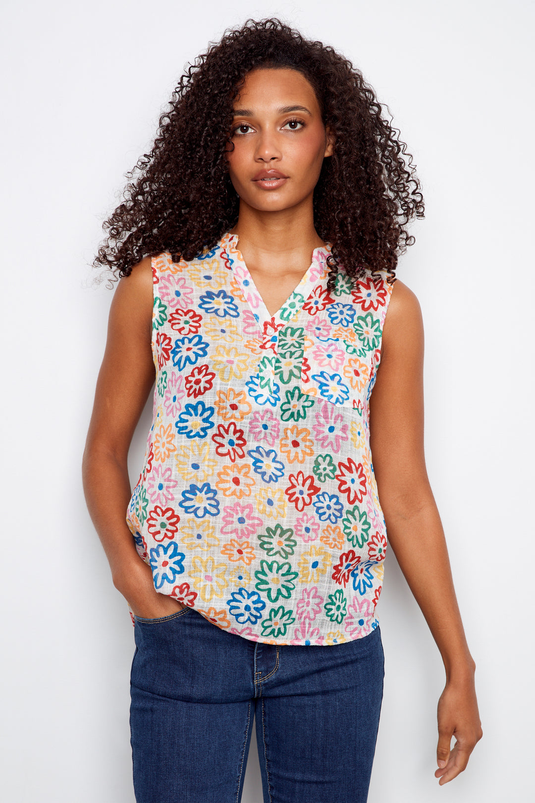 Woman wearing a sleeveless floral blouse with a white background