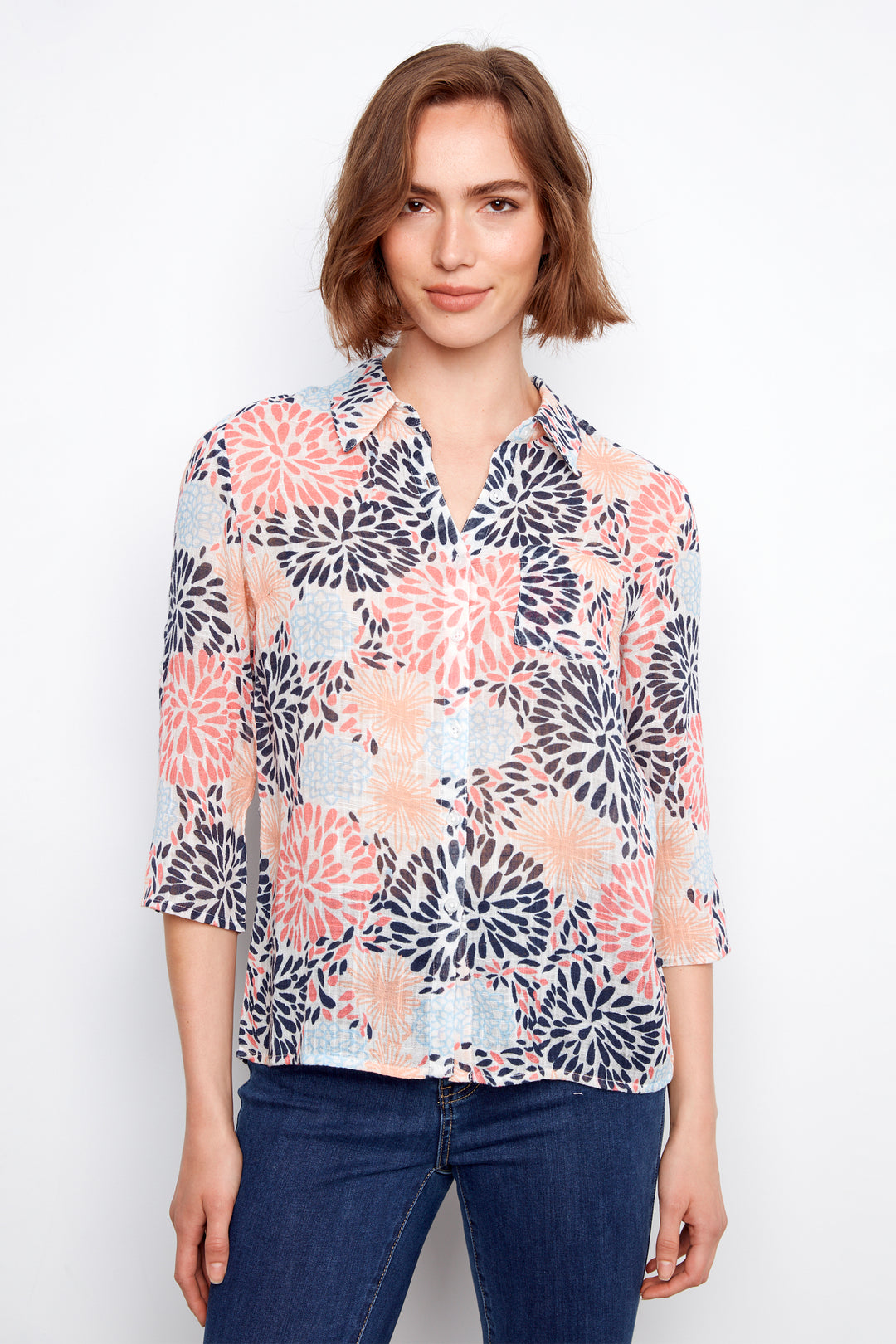 Woman wearing a floral blouse with blue jeans on a white background
