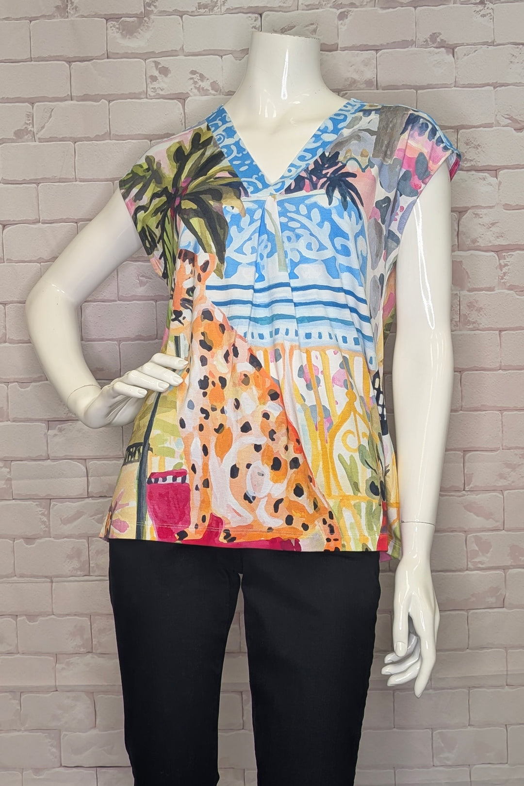 Colorful patterned top on a mannequin against a brick wall background