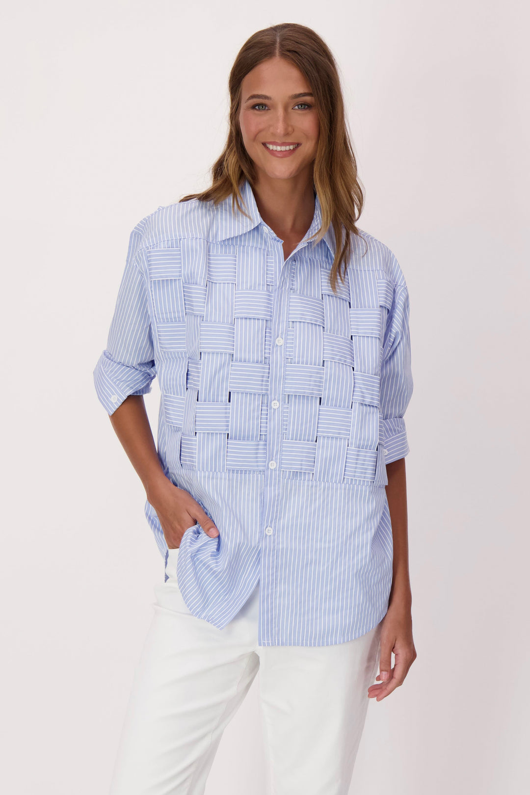 Woman wearing a blue and white checkered stripe basketweave shirt with a textured pattern on a light background