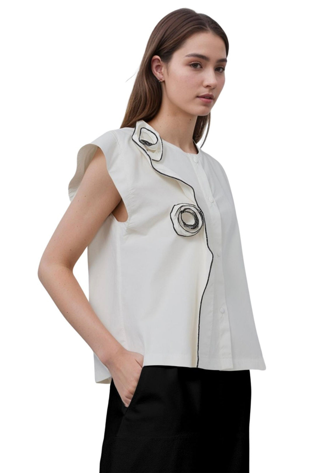 Woman wearing a white sleeveless cotton top with black rose accents on a white background