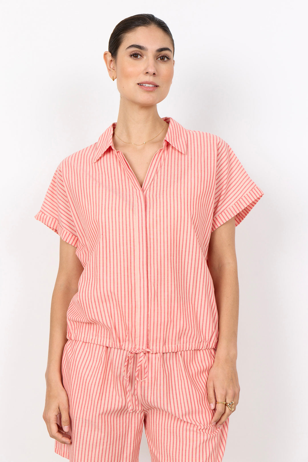 Woman wearing a red and white striped outfit with front tie drawstring on a white backgrougrund