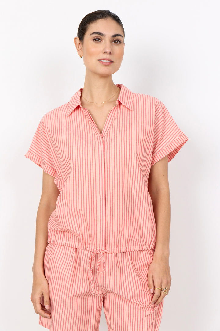 Woman wearing a red and white striped outfit with front tie drawstring on a white backgrougrund