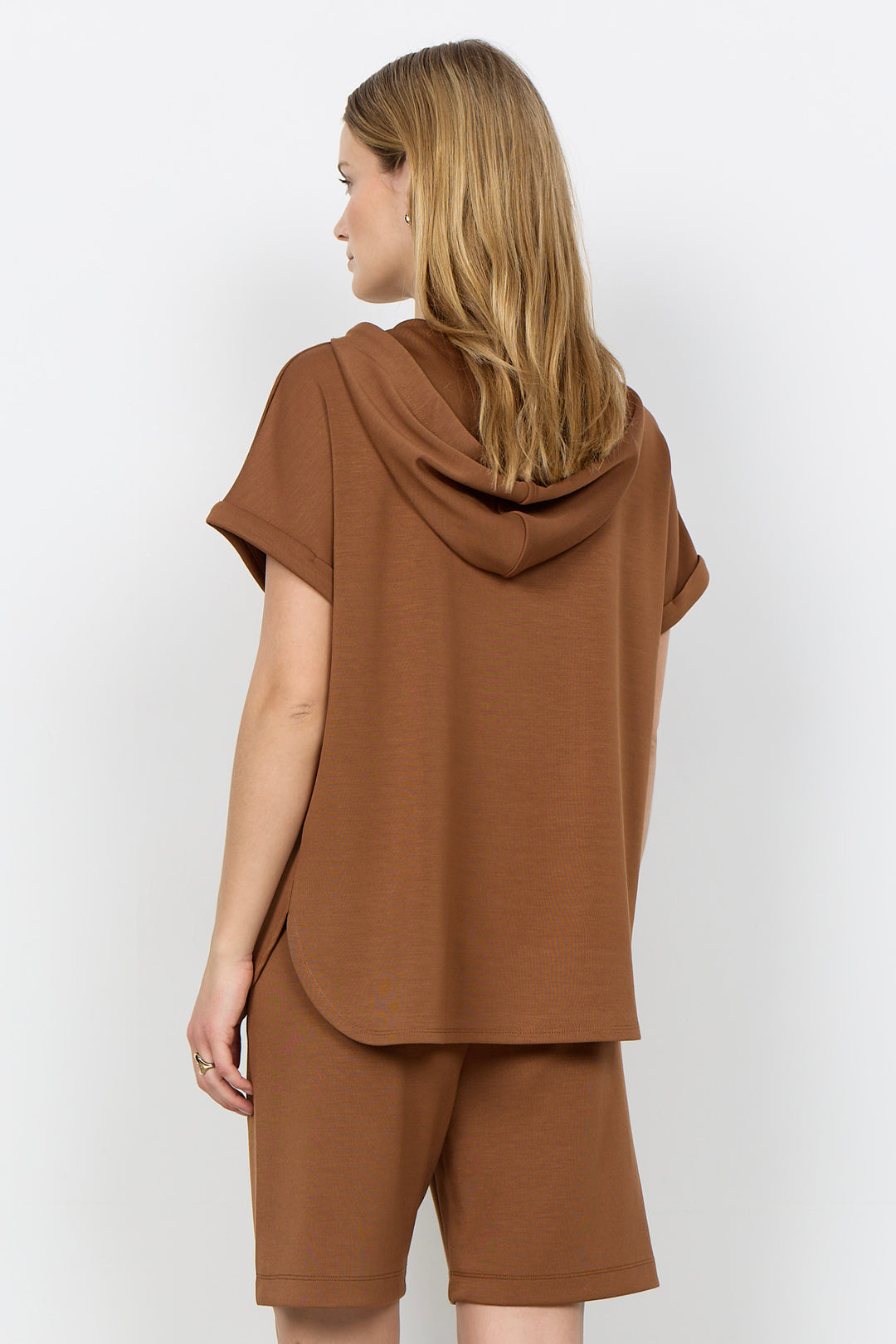Woman wearing a toffee brown-colored outfit with a plain background
