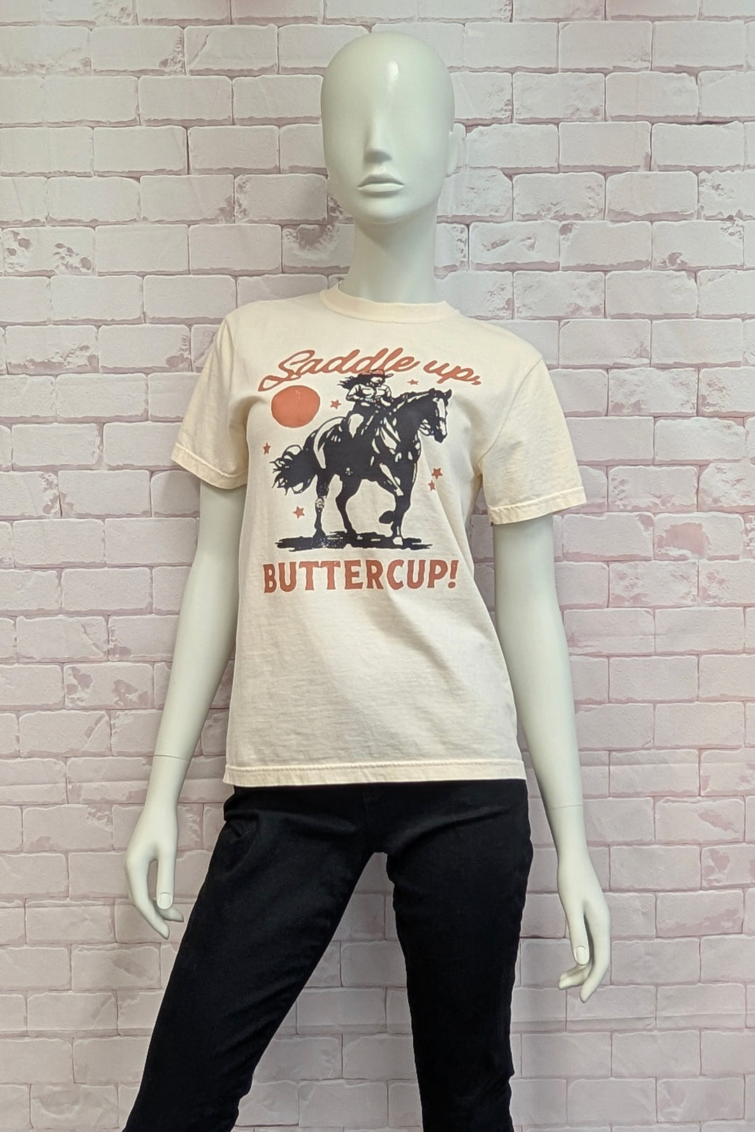 Mannequin wearing a t-shirt with a graphic design against a brick wall background