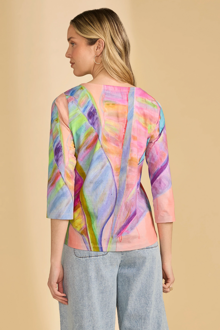 Woman wearing a colorful, patterned top with a beige background