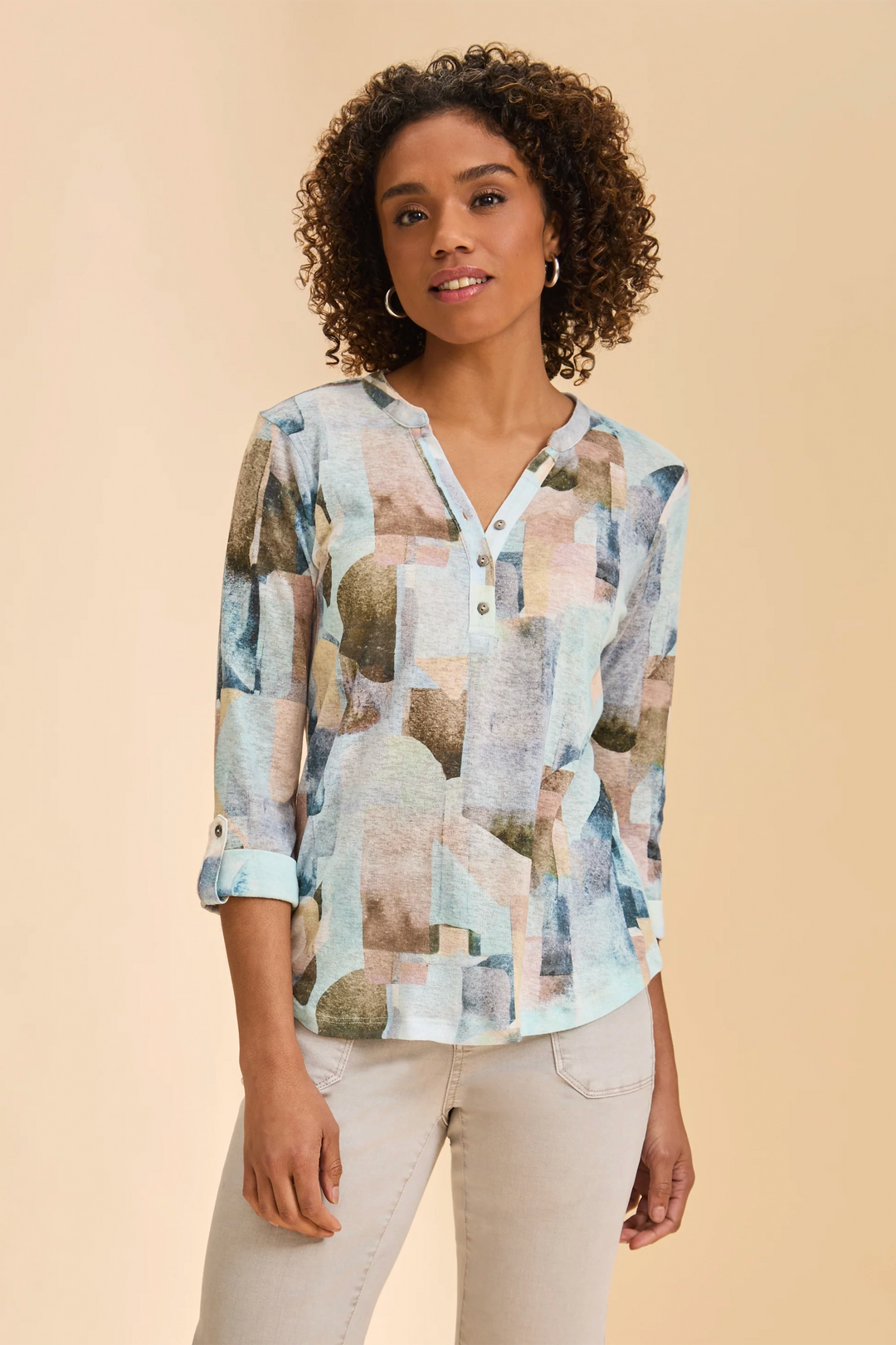 Woman wearing a patterned blouse against a beige background