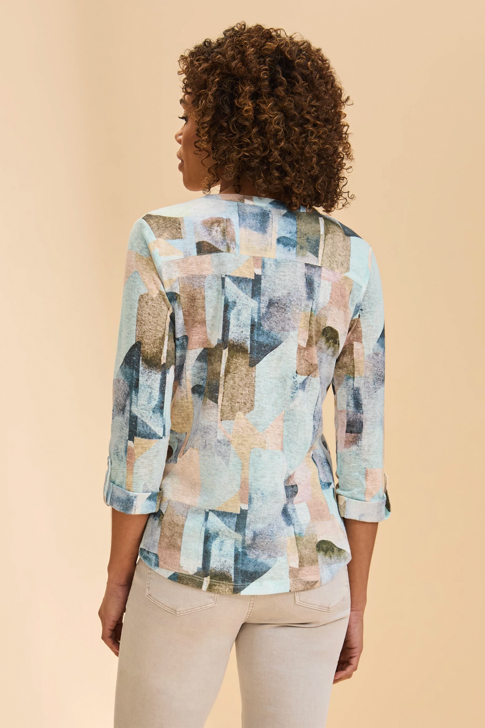 Woman wearing a patterned blouse against a beige background