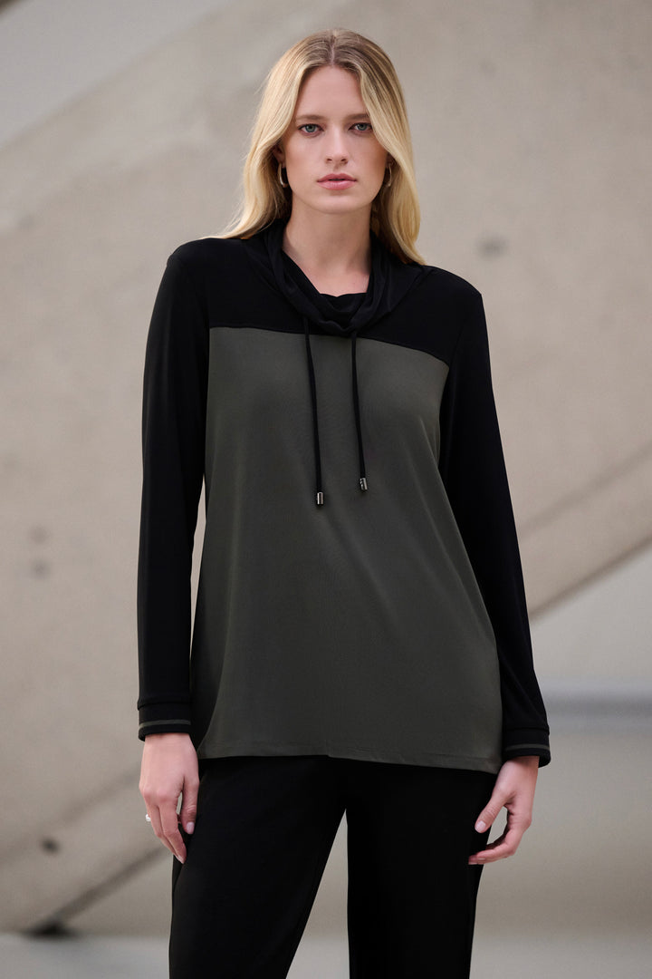 Woman wearing a black and gray long-sleeve cowl neck top against a neutral background